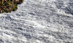 Superficie a spacco naturale di marmo a letti sottili chiari e scuri, ricco di mica e altri silicati (calcescisti auct.)