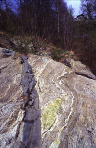 Il dicco di Courtil taglia di sbieco i piani di foliazione della roccia incassante: è dunque posteriore ad essi